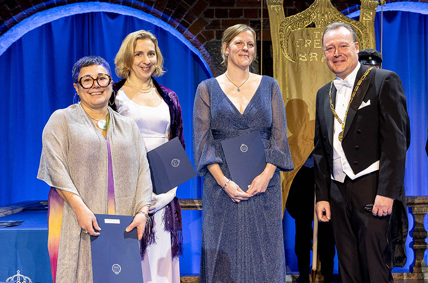 Treleende kvinnor i aftonklänning och en man i frack.