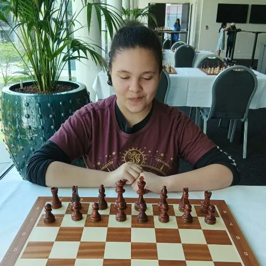 Paula Claudio in front of a chess game. 